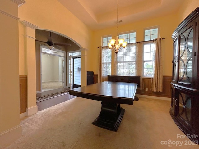 game room featuring a raised ceiling, light colored carpet, a towering ceiling, and ceiling fan with notable chandelier