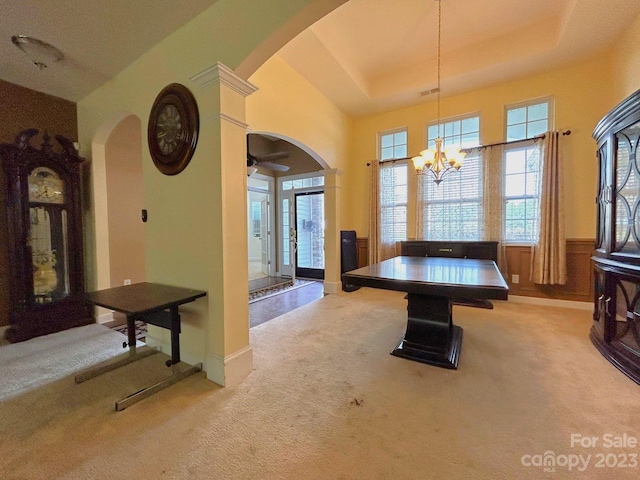 game room featuring a raised ceiling, ceiling fan with notable chandelier, and light colored carpet