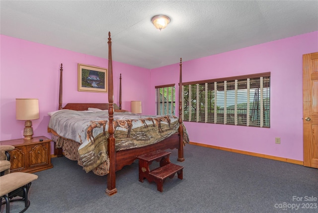 bedroom featuring a textured ceiling and dark carpet