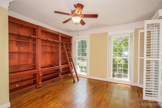 spare room with ceiling fan, a wealth of natural light, ornamental molding, and dark hardwood / wood-style floors