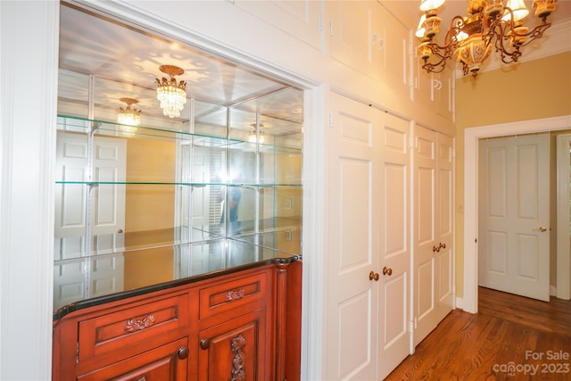 hallway with a notable chandelier and dark hardwood / wood-style floors