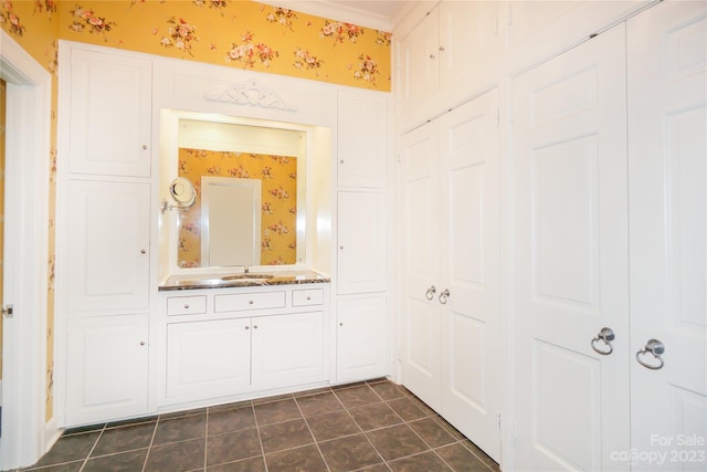 bathroom featuring tile flooring, vanity with extensive cabinet space, and ornamental molding