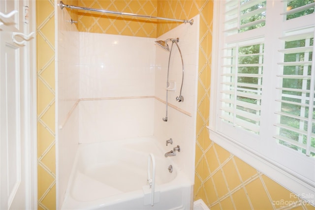 bathroom with radiator heating unit and tiled shower / bath combo