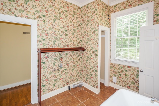 bathroom with a bath to relax in, tile floors, and ornamental molding