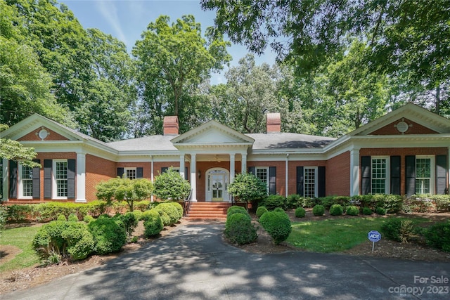 greek revival inspired property featuring a front yard