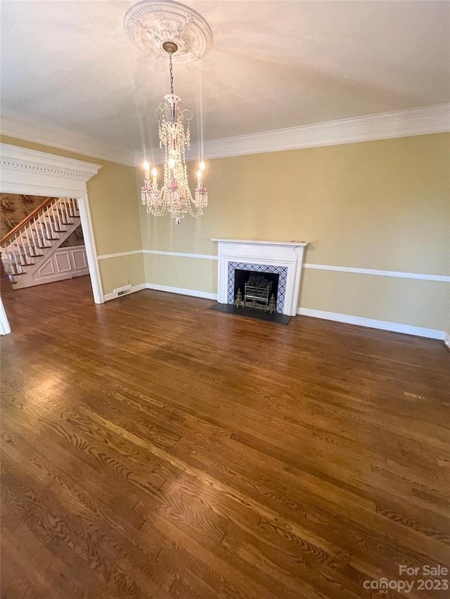 unfurnished living room with an inviting chandelier, crown molding, and dark hardwood / wood-style floors