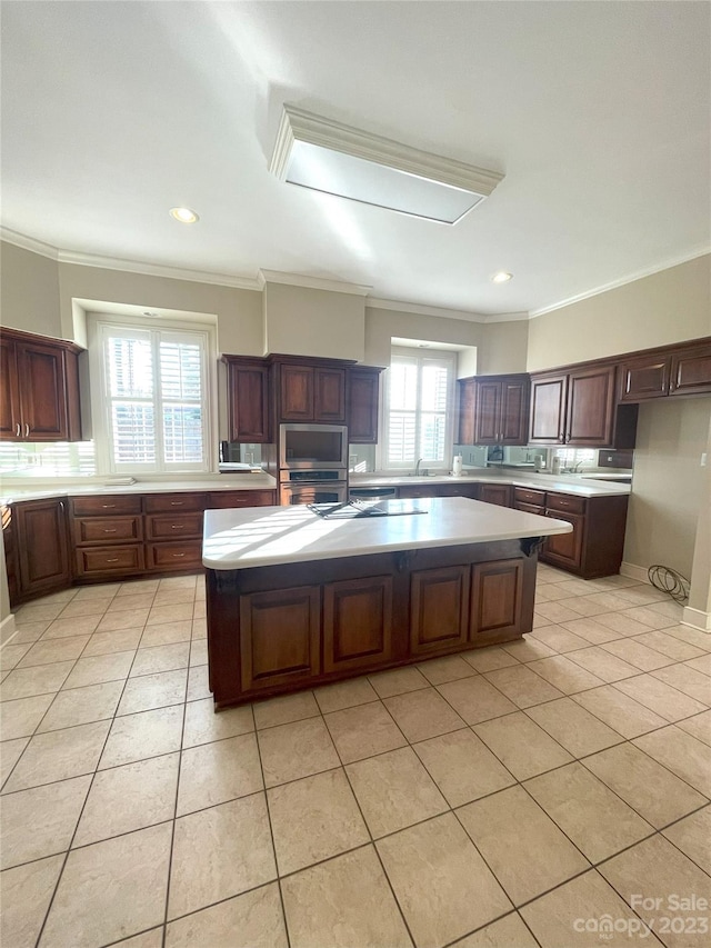 kitchen with stainless steel appliances, ornamental molding, and a center island