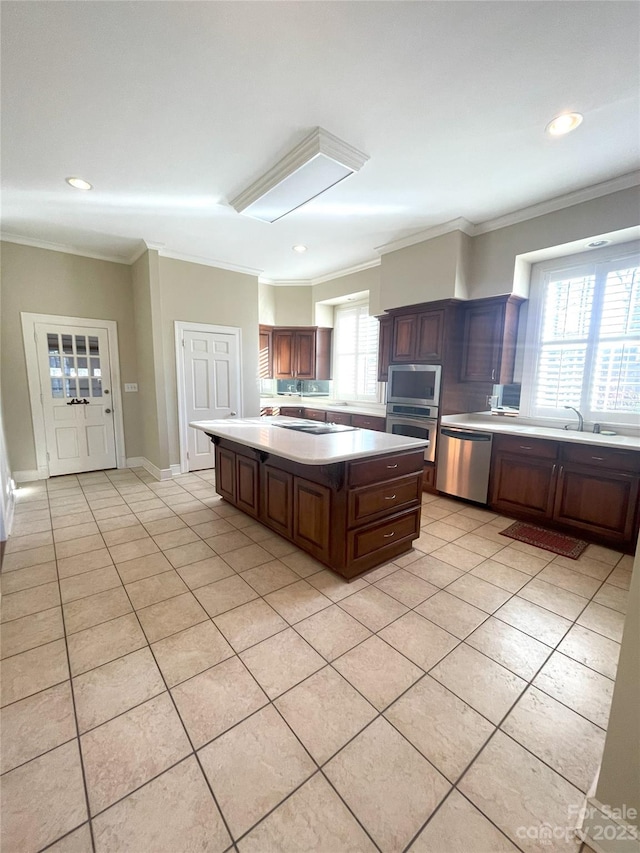 kitchen featuring light tile floors, a kitchen island, appliances with stainless steel finishes, and a wealth of natural light