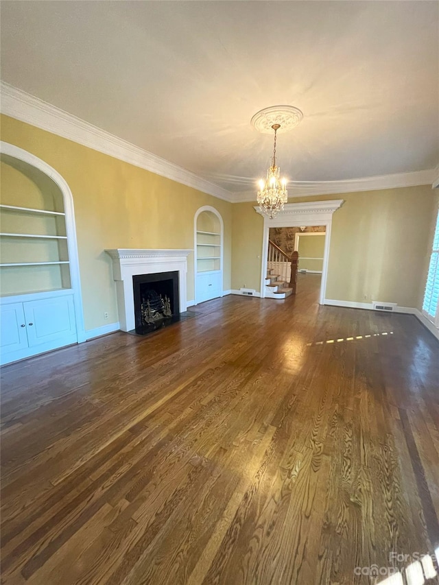 unfurnished living room with built in shelves, a notable chandelier, and dark hardwood / wood-style floors