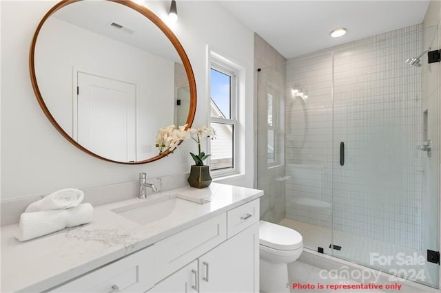 bathroom featuring vanity, toilet, and walk in shower