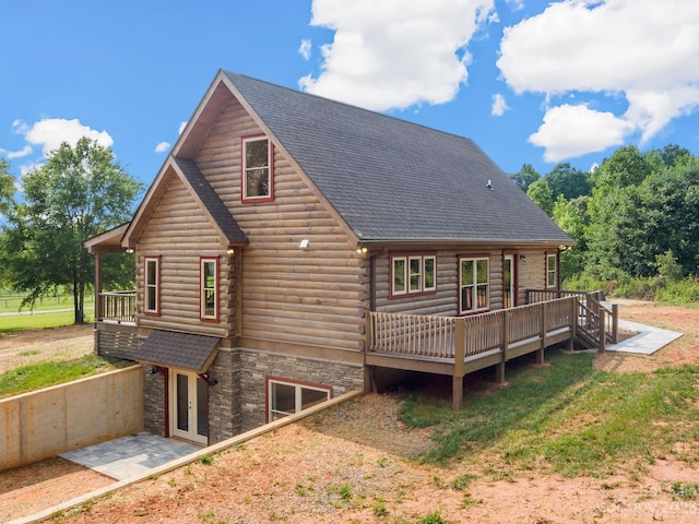 back of property featuring a deck and a patio