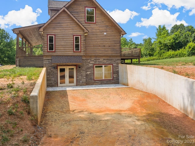 rear view of house with a deck, french doors, and a patio