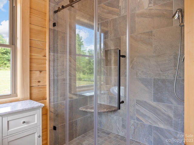 bathroom featuring a shower with shower door and vanity