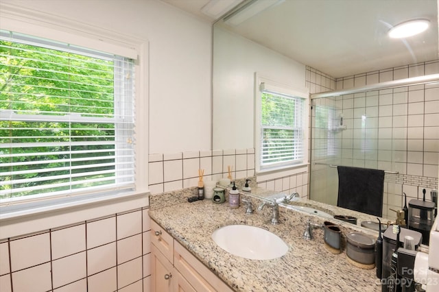 bathroom with plenty of natural light, backsplash, oversized vanity, and tile walls