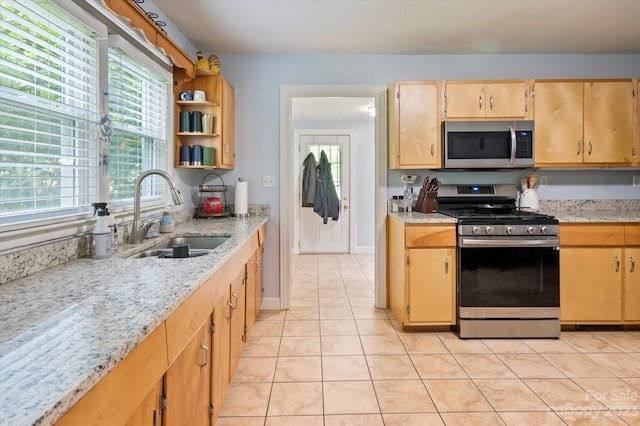 kitchen featuring light stone countertops, light tile flooring, sink, and stainless steel appliances