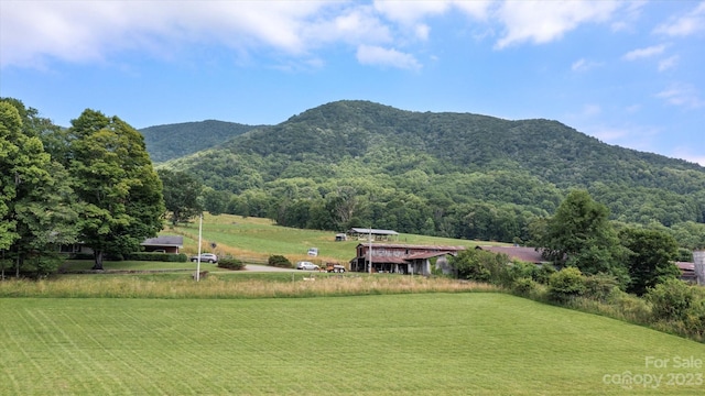 exterior space with a rural view, a lawn, and a mountain view