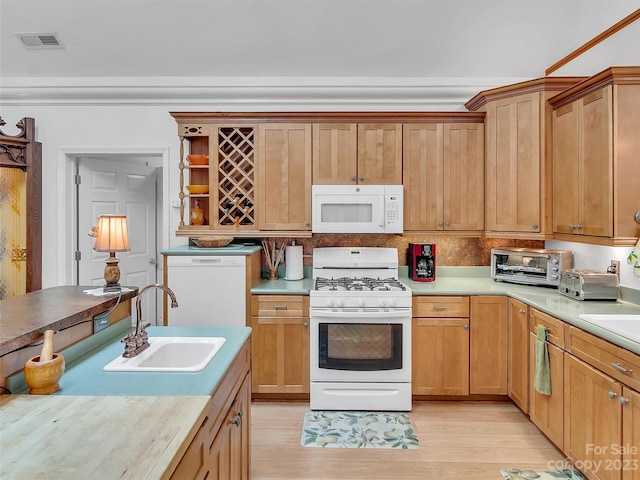 kitchen with light hardwood / wood-style floors, white appliances, and sink