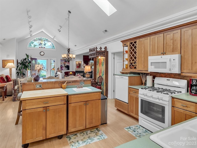 kitchen featuring light hardwood / wood-style flooring, a notable chandelier, white appliances, and lofted ceiling with skylight