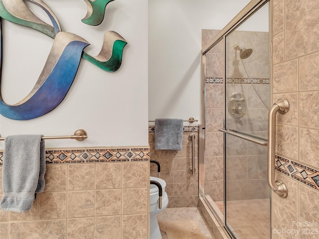 bathroom featuring a shower with shower door and toilet