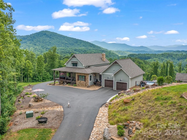 view of front facade with covered porch, a mountain view, and a garage