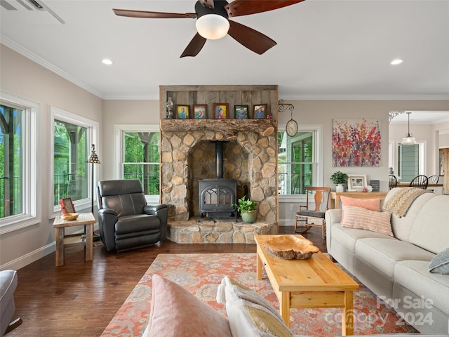 living room with dark hardwood / wood-style floors, ceiling fan, a wood stove, and crown molding