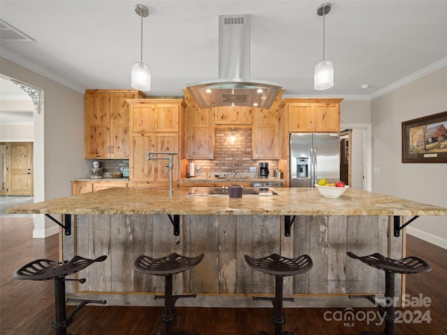 kitchen featuring island exhaust hood, stainless steel refrigerator with ice dispenser, backsplash, a kitchen breakfast bar, and black electric cooktop