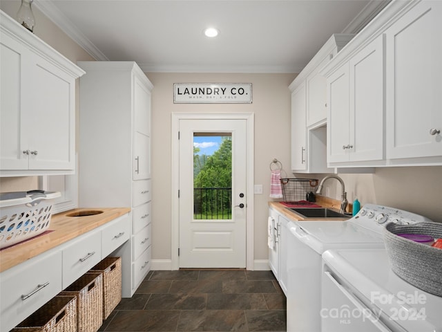 laundry room featuring washer and clothes dryer, crown molding, cabinets, and sink