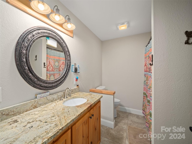 bathroom with tile patterned flooring, vanity, and toilet