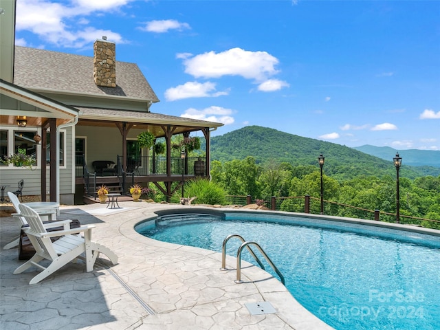 view of swimming pool featuring a patio area and a mountain view