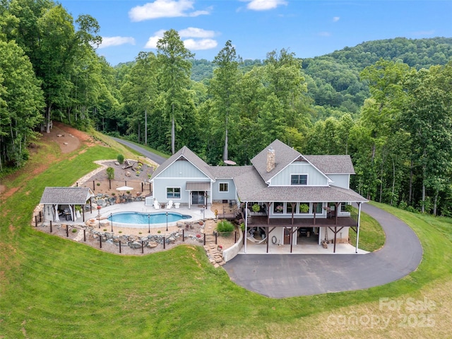1590 S 226th Hwy, Bakersville, NC 28705 - back of property with board and batten siding, an outdoor pool, a view of trees, and a yard