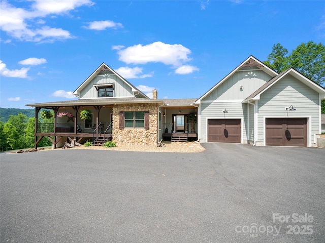 1590 S 226th Hwy, Bakersville, NC 28705 - view of front facade with aphalt driveway, board and batten siding, a porch, stone siding, and a garage