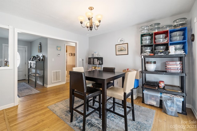 dining space with a notable chandelier and light wood-type flooring