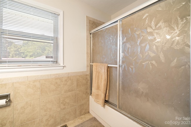 bathroom with bath / shower combo with glass door