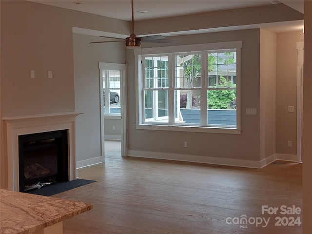 unfurnished living room featuring wood-type flooring and ceiling fan