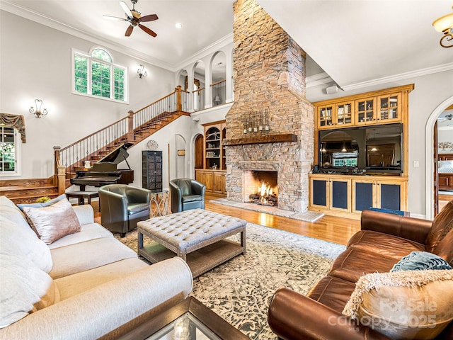 202 Emerald Ln, Maggie Valley, NC 28751 - living room with a ceiling fan, crown molding, wood finished floors, a stone fireplace, and arched walkways