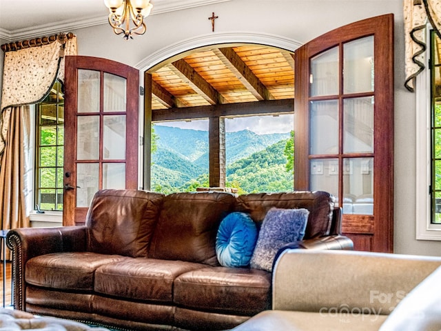202 Emerald Ln, Maggie Valley, NC 28751 - living area featuring a mountain view, a chandelier, beamed ceiling, ornamental molding, and wood ceiling