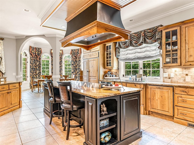 202 Emerald Ln, Maggie Valley, NC 28751 - kitchen with arched walkways, custom exhaust hood, a sink, light tile patterned floors, and crown molding