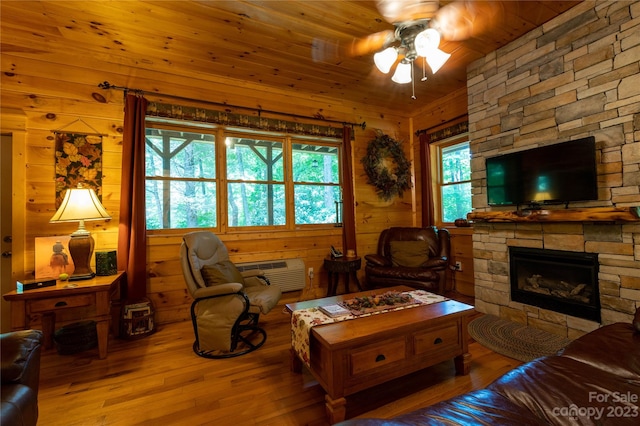 living room featuring wood walls, wooden ceiling, ceiling fan, and light hardwood / wood-style flooring