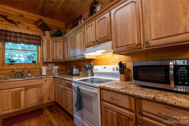 kitchen featuring light stone countertops, wooden walls, white range with electric stovetop, and light wood-type flooring