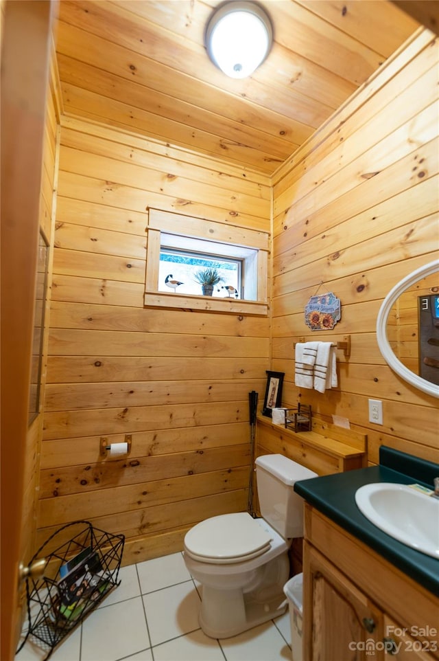 bathroom with tile flooring, wood walls, toilet, wood ceiling, and vanity