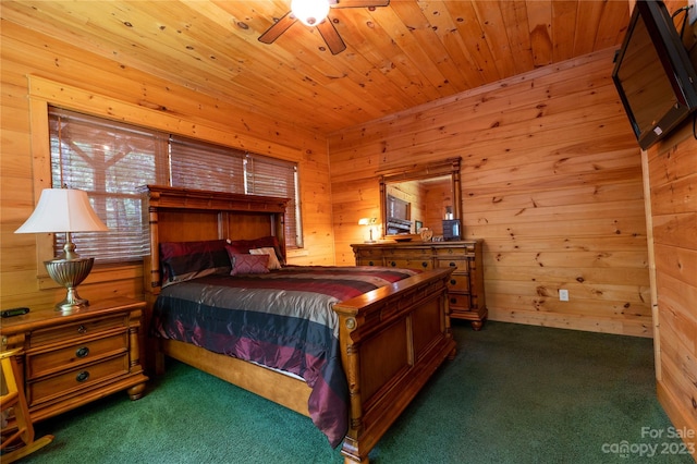 bedroom featuring wood ceiling, dark colored carpet, wood walls, and ceiling fan