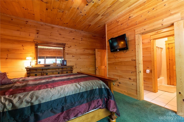 carpeted bedroom featuring wood walls, wooden ceiling, and ensuite bath