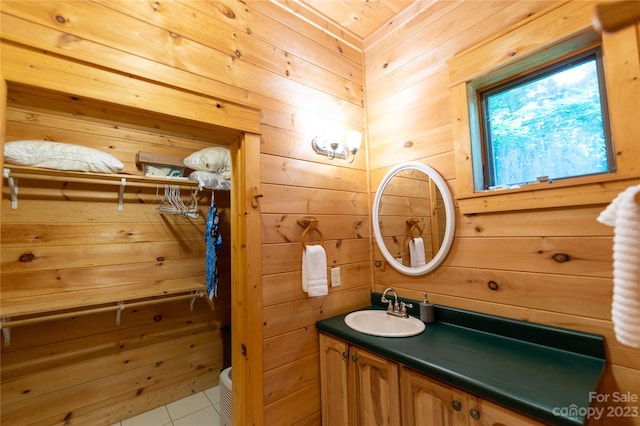 bathroom with wooden walls, vanity, toilet, and tile floors