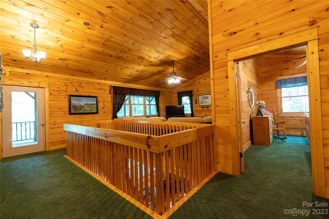 interior space with an inviting chandelier, wooden ceiling, wood walls, and dark colored carpet