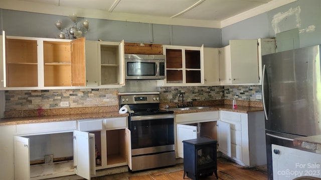 kitchen with stainless steel appliances, light hardwood / wood-style floors, decorative backsplash, a notable chandelier, and sink