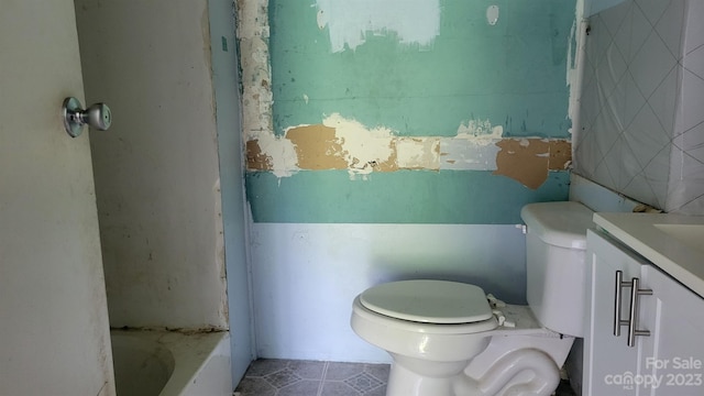 bathroom featuring tile patterned floors, vanity, toilet, and a bathtub