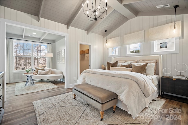 bedroom featuring a spacious closet, vaulted ceiling with beams, a notable chandelier, wood-type flooring, and a closet