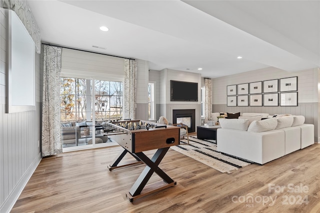 rec room featuring wood walls and light hardwood / wood-style floors