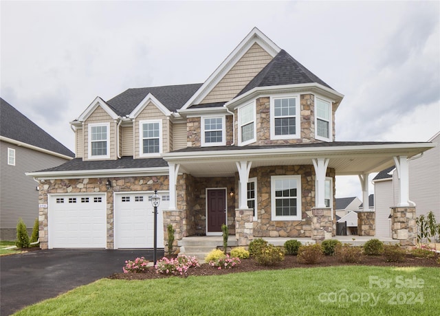 view of front facade with a front yard, a garage, and covered porch