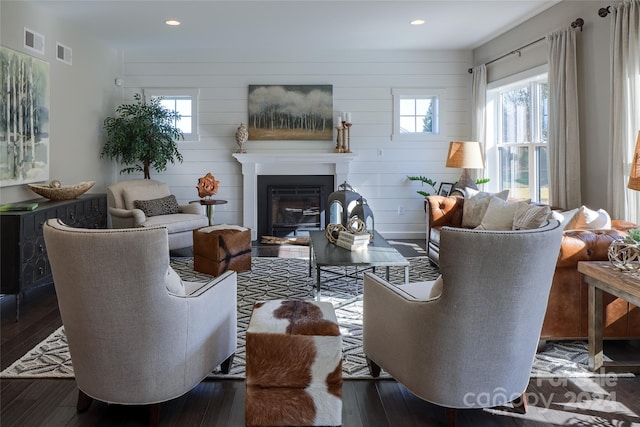 living room with wooden walls and dark wood-type flooring